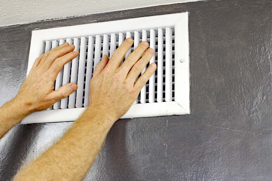 Why Is My AC Blowing Hot Air? Hands in fron tof vent.