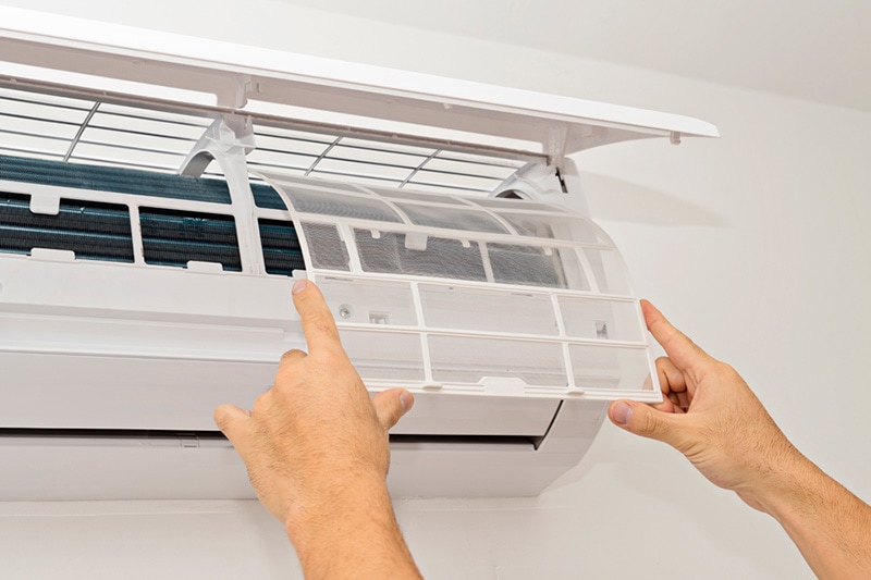 What Maintenance Is Needed for a Ductless System? Person replacing the filter on a ductless system.