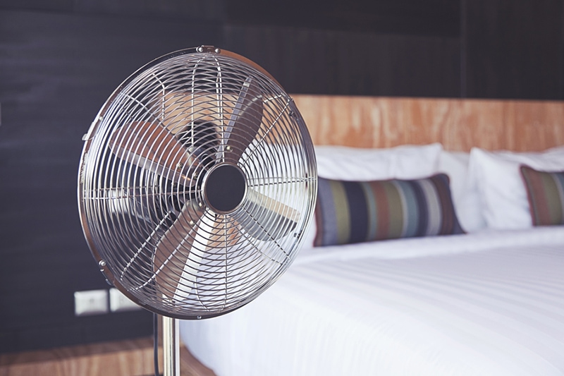 Bedroom with electric fan inside of it.