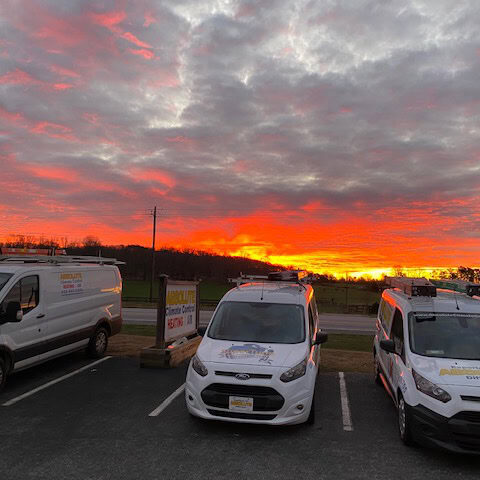 Absolute Climate Control service trucks at sunset.