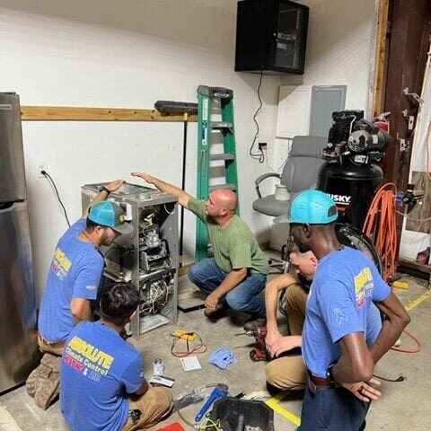 The Absolute Climate Control team performing HVAC maintenance.